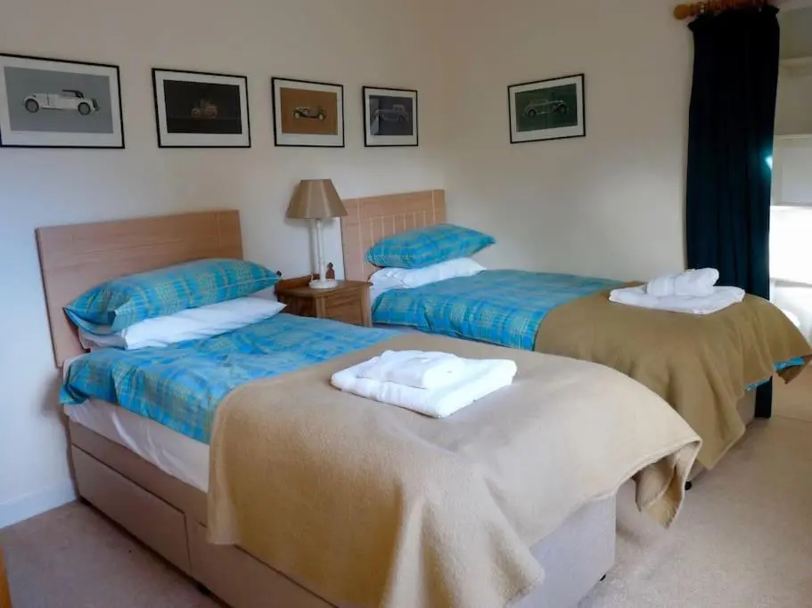 two beds in a hotel room with towels on them at Tornacraig 8 Person Country House on Royal Deeside in Aboyne