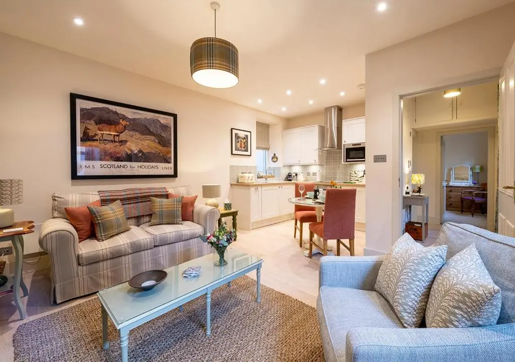 a living room with two couches and a table at The Hideaway in Inverness