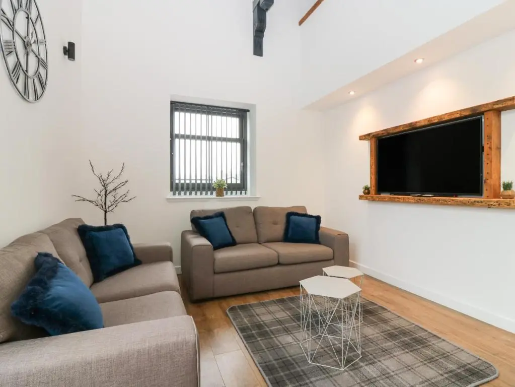 a living room with two couches and a flat screen tv at The Dance Hall, The Institute Executive Apartments in Keith