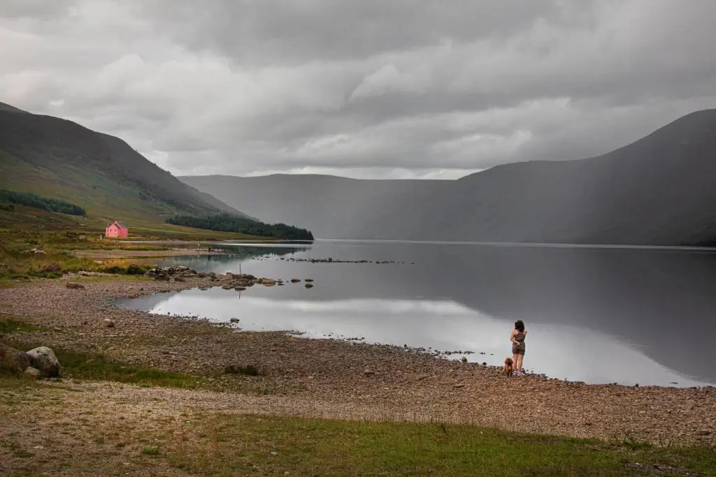 a woman standing on the shore of a lake at Cuillich Mill Bed and Breakfast in the Highlands in Alness
