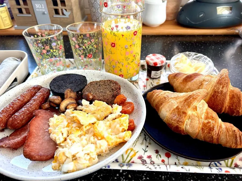 a table with a plate of breakfast food and bread at Cuillich Mill Bed and Breakfast in the Highlands in Alness