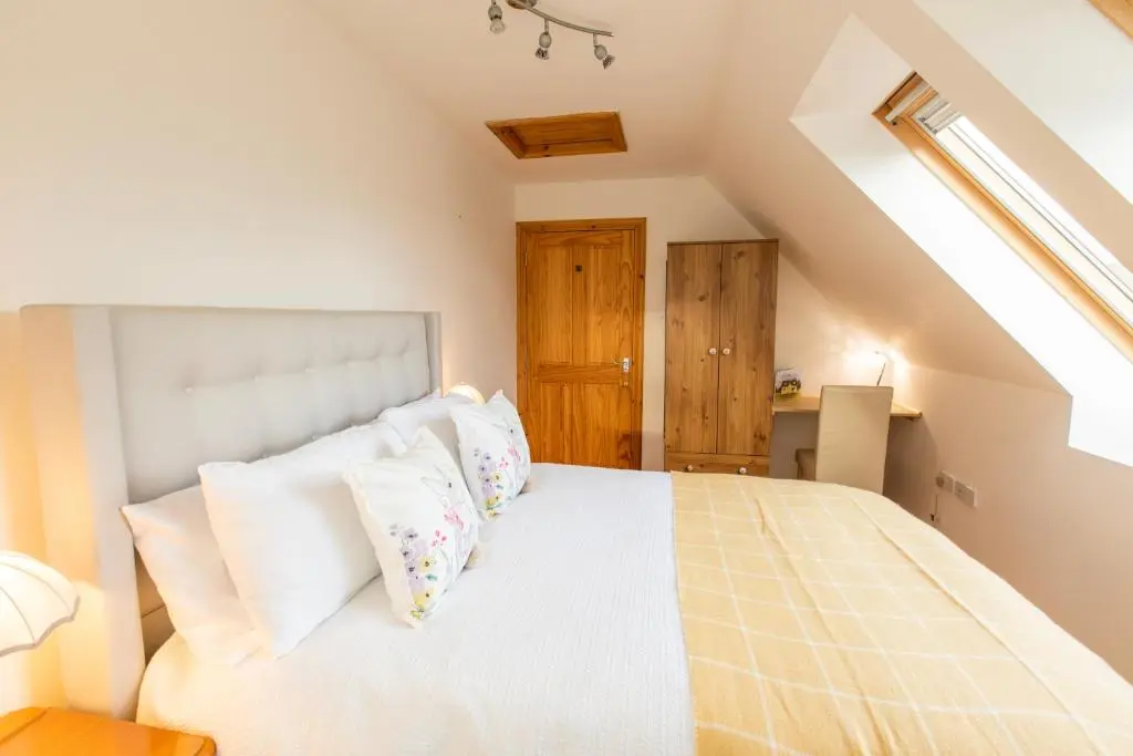 a bedroom with a white bed with white pillows at Cuillich Mill Bed and Breakfast in the Highlands in Alness