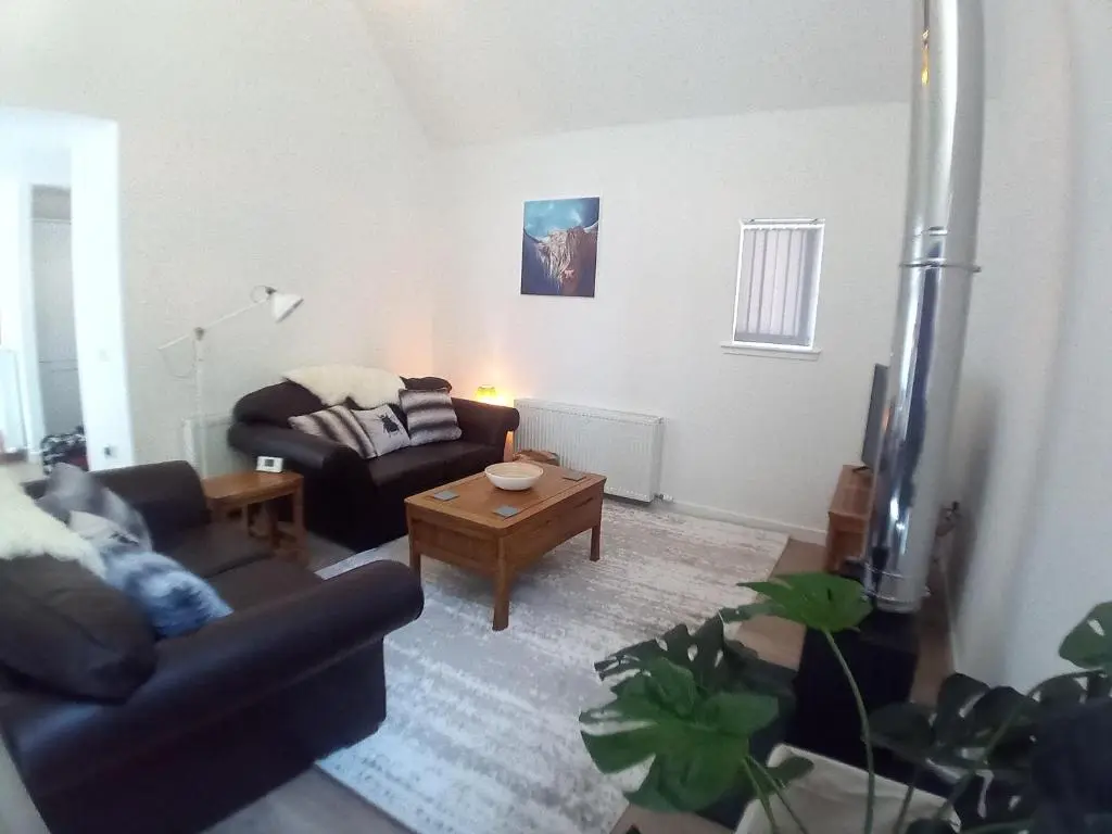 a living room with a couch and a coffee table at Sawmill Cottage in Grantown on Spey