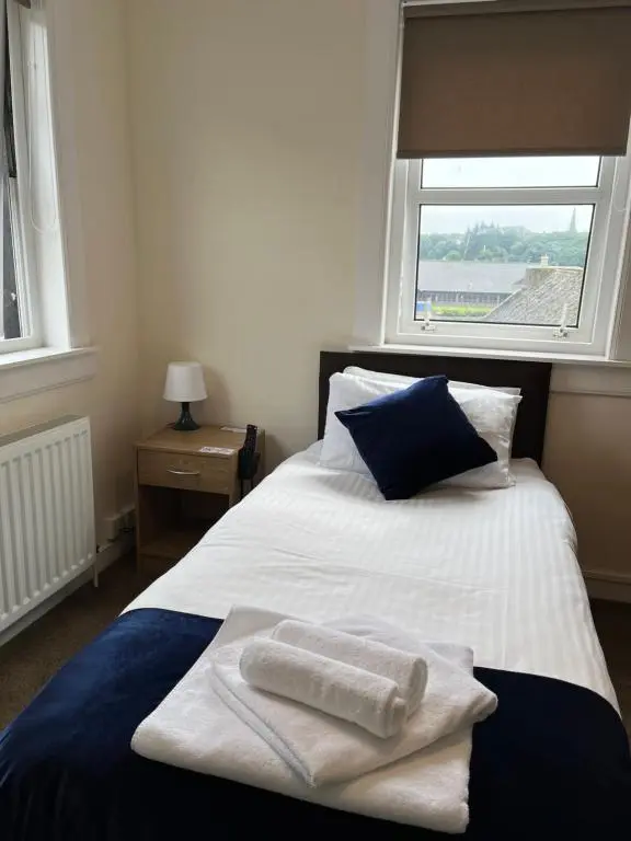 a bedroom with a bed with towels on it at Caithness Inn in Wick