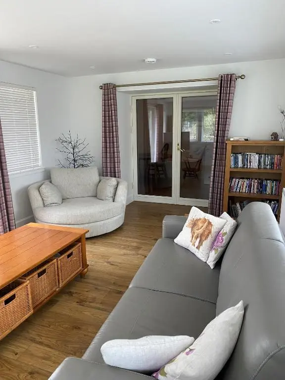 a living room with a couch and a table at Cosy Cottage in beautiful Royal Deeside in Aboyne