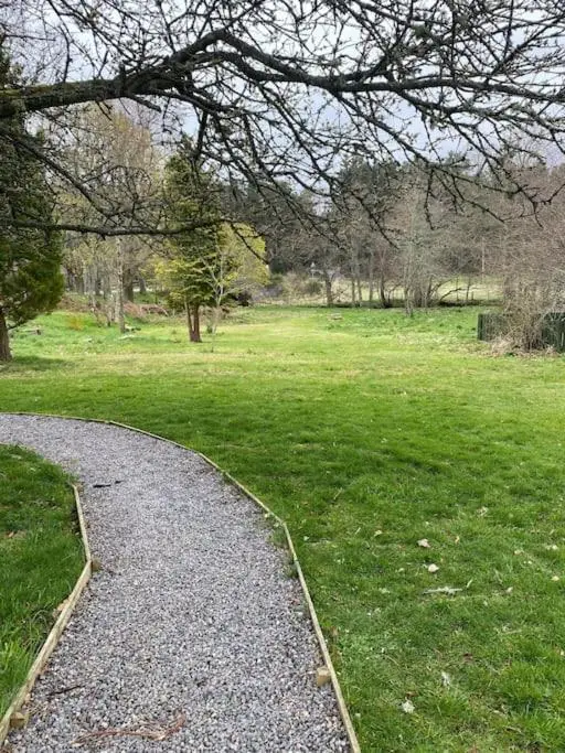a gravel path in a park with a grass field at Cosy Cottage in beautiful Royal Deeside in Aboyne