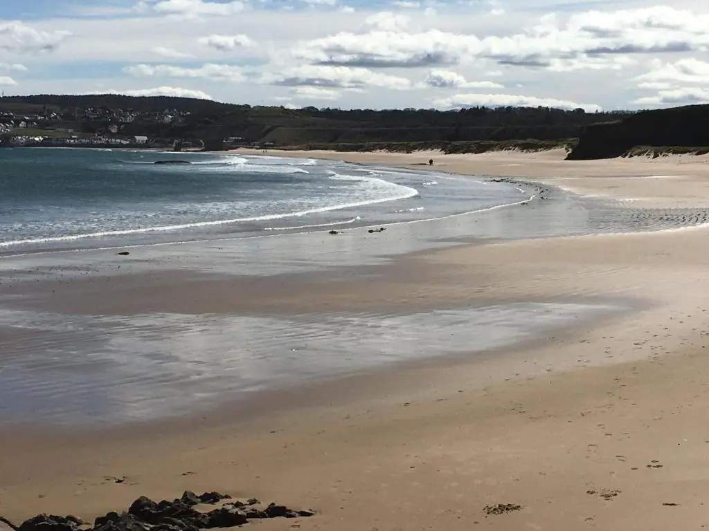 a sandy beach with waves coming in from the ocean at Zen Cottage Cullen - Sleeps 4 Garden & Pets Ok in Cullen