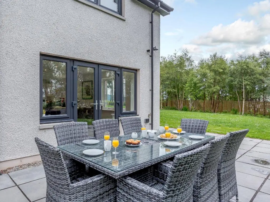 a black table with chairs and drinks on a patio at Strathclaggan in Aberlour