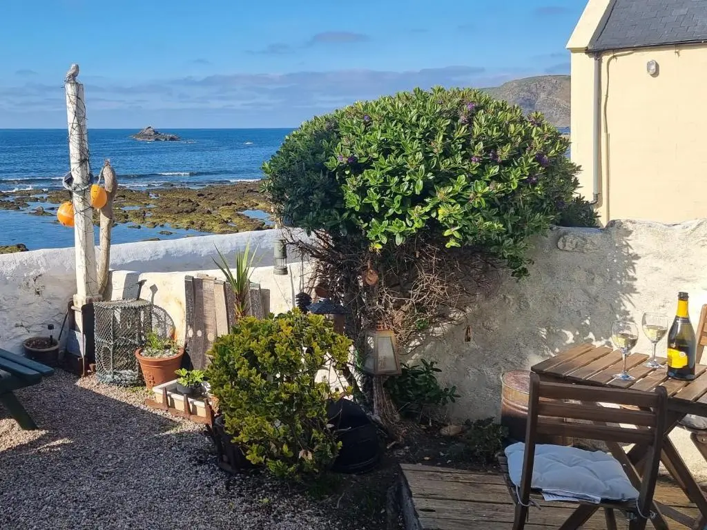 a patio with a table and a view of the ocean at The Windowky in Gardenstown