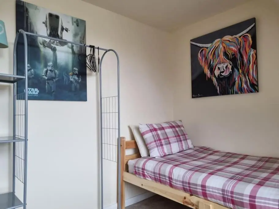 a bedroom with a bed and a painting on the wall at Clava Cottage City Centre in Inverness
