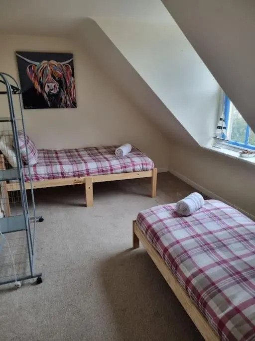 a attic room with two beds and a window at Clava Cottage City Centre in Inverness