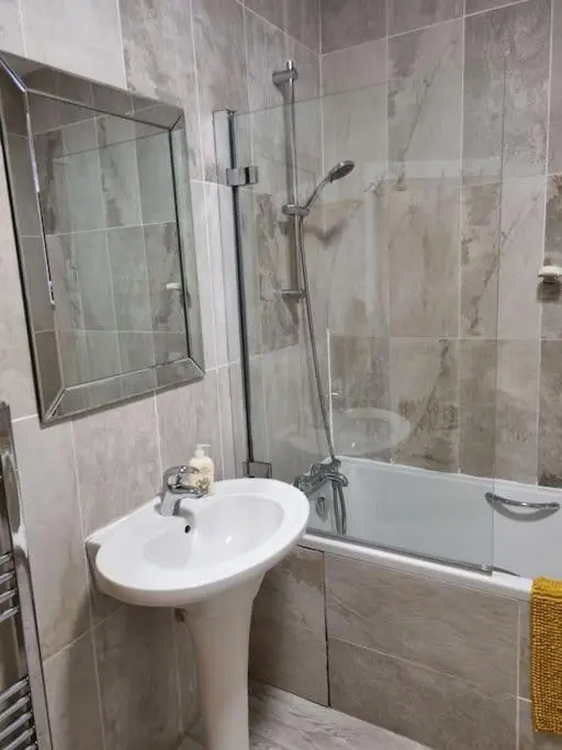 a bathroom with a sink and a shower and a tub at Clava Cottage City Centre in Inverness