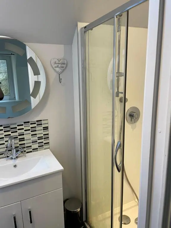 a bathroom with a shower and a sink at Newsagents Flat in Lairg