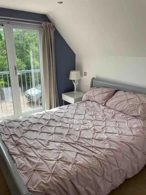 a bedroom with a large bed with a window at Corriegorm Cottage, Aviemore in Aviemore