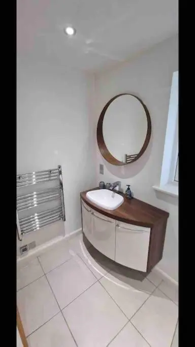 a bathroom with a sink and a mirror at Corriegorm Cottage, Aviemore in Aviemore