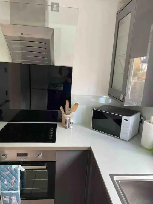 a kitchen with a microwave and a stove top oven at Corriegorm Cottage, Aviemore in Aviemore