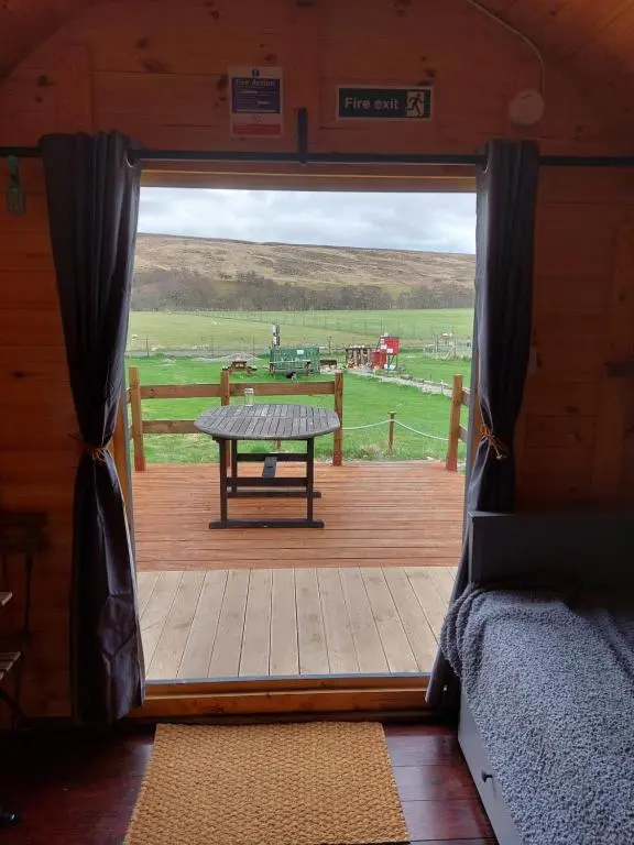 a view of a wooden porch with a picnic table at Pod 4 in Skail
