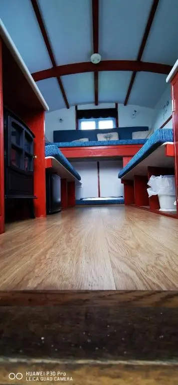 an empty room with bunk beds and a wooden floor at Gypsy hut in Newtonmore