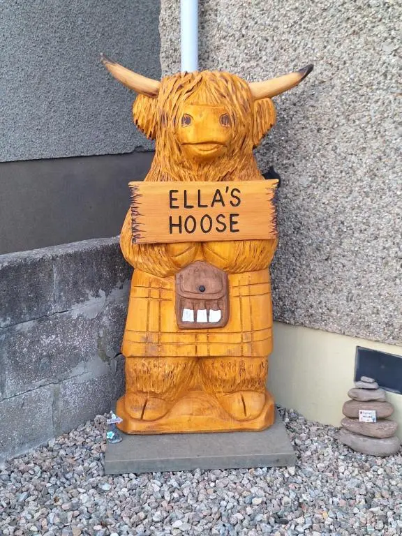 a statue of a cow with a house sign on it at Ella's Hoose in Wick