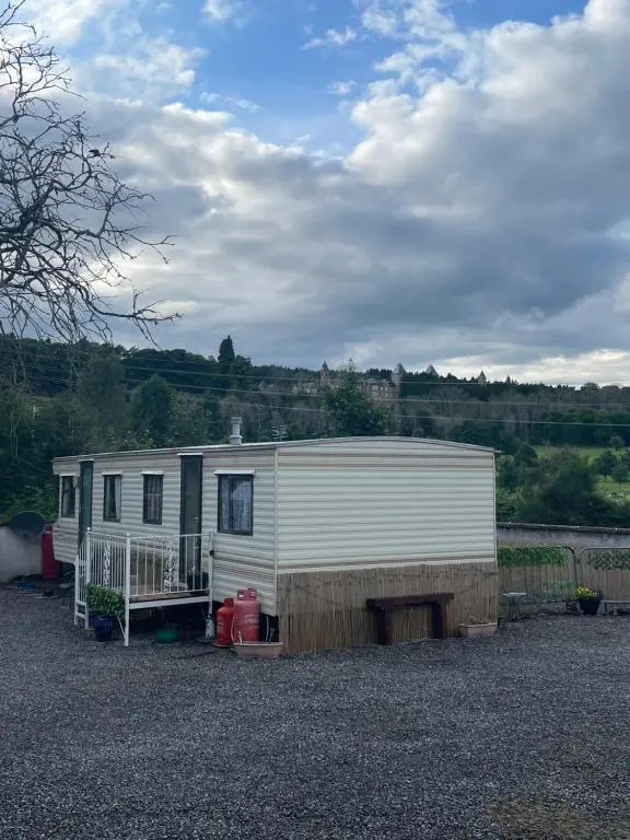 a white trailer parked in a gravel parking lot at Caravan at Charleston House in Inverness