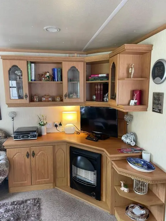 a room with a desk with a tv and a fireplace at Caravan at Charleston House in Inverness