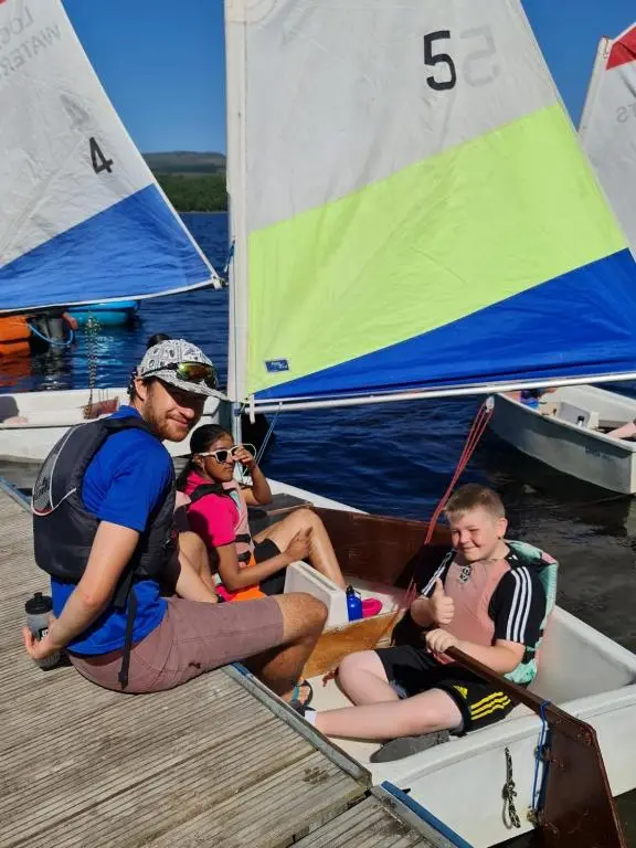 a group of people sitting in a small sail boat at Loch Insh Chalets and Apartments in Kincraig