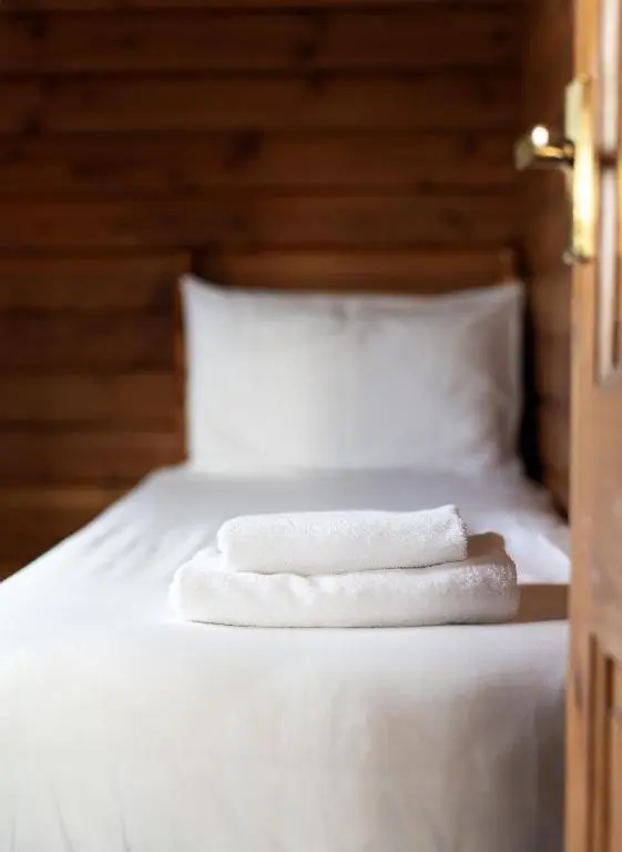 two towels sitting on top of a bed at Loch Insh Chalets and Apartments in Kincraig