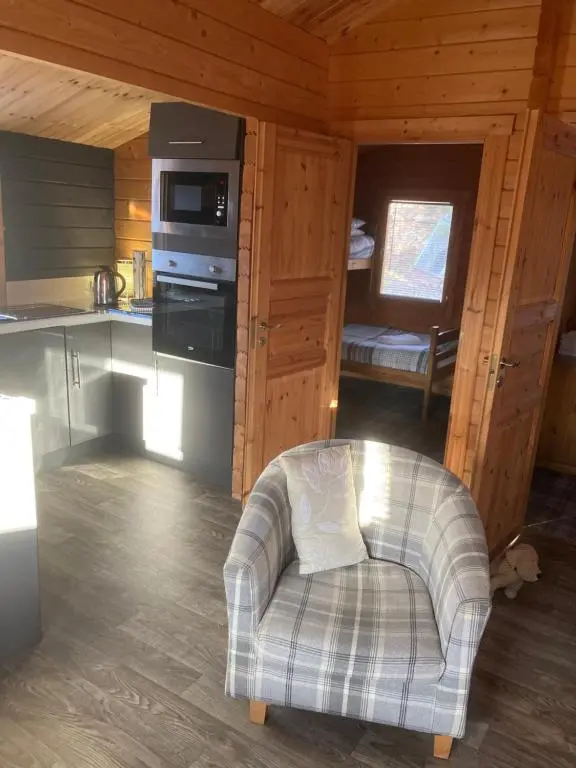 a kitchen with a chair in a cabin at Log Cabin in the City with hot tub in Culloden