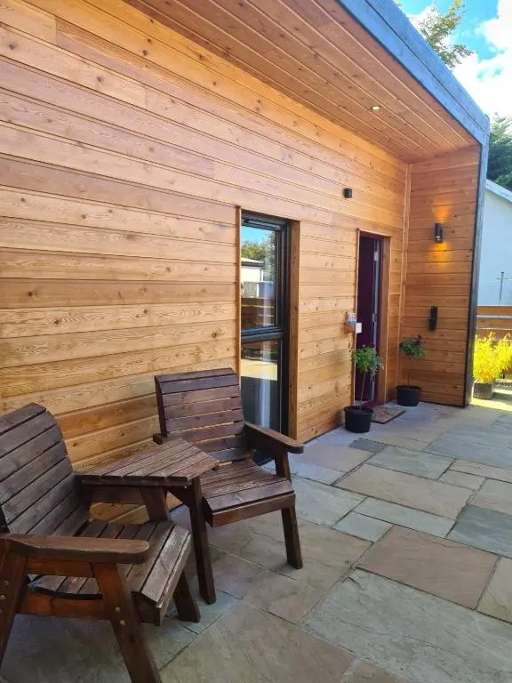 two benches on a patio with a wooden wall at The Hide in Ullapool