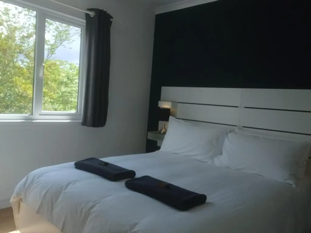 a bedroom with a bed with two towels on it at Gynack Villa in Kingussie