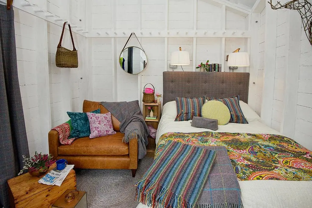 a bedroom with a bed and a couch and a chair at Laggan Bothies in Spean Bridge
