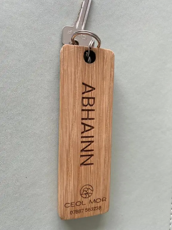 a wooden key chain with the words godini muchify faster at Ceol Mor Highland Lodges in Lairg