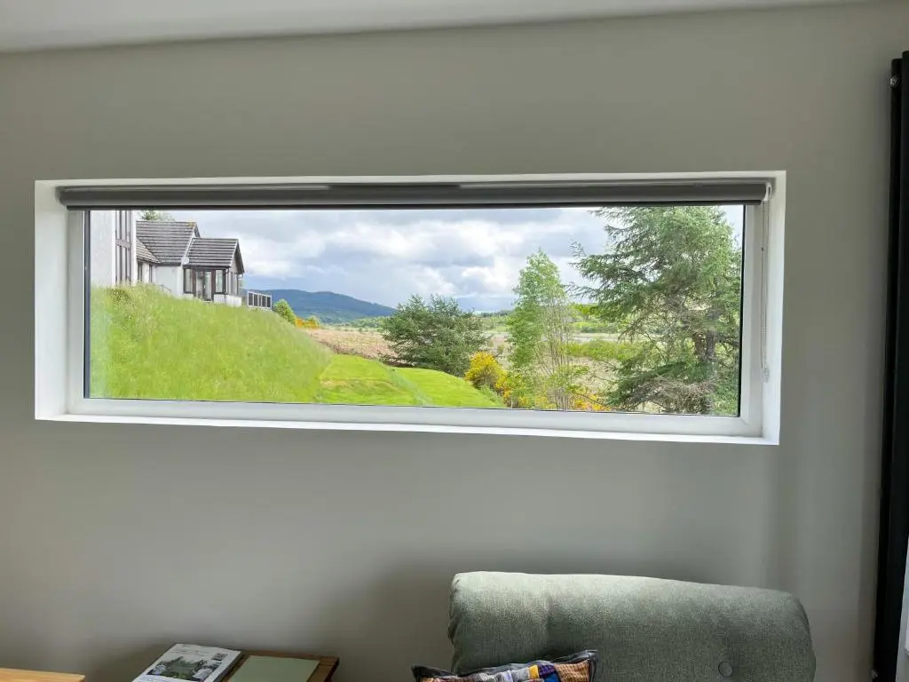 a window with a view of a house at Ceol Mor Highland Lodges in Lairg
