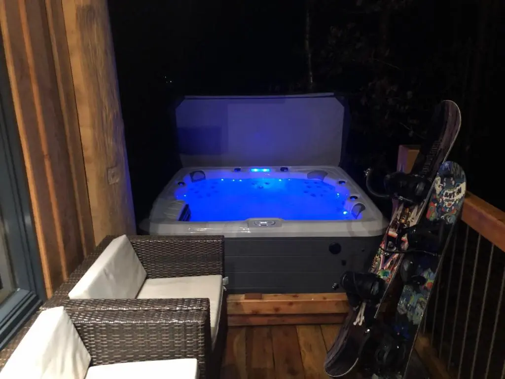 a jacuzzi tub on a balcony with a snowboard at Pine Marten Lodge in Grantown on Spey