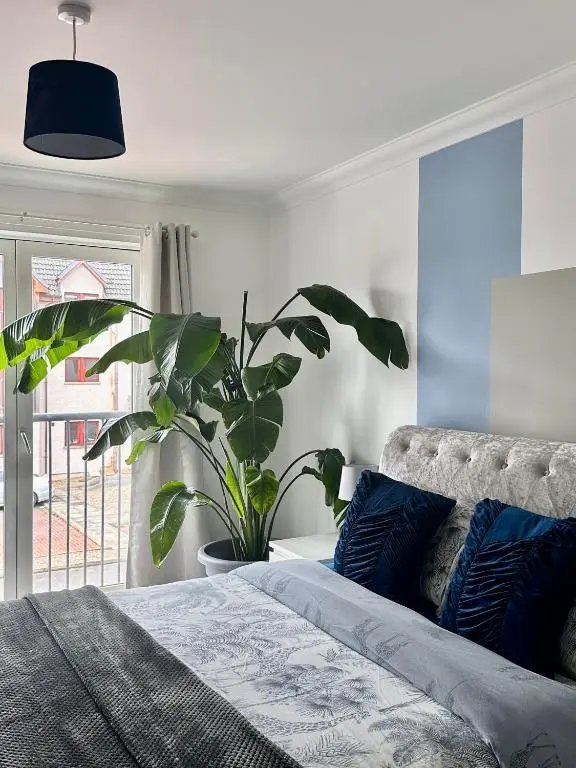 a bedroom with a bed and a potted plant at The Meadow, River view apartment in South Kessock