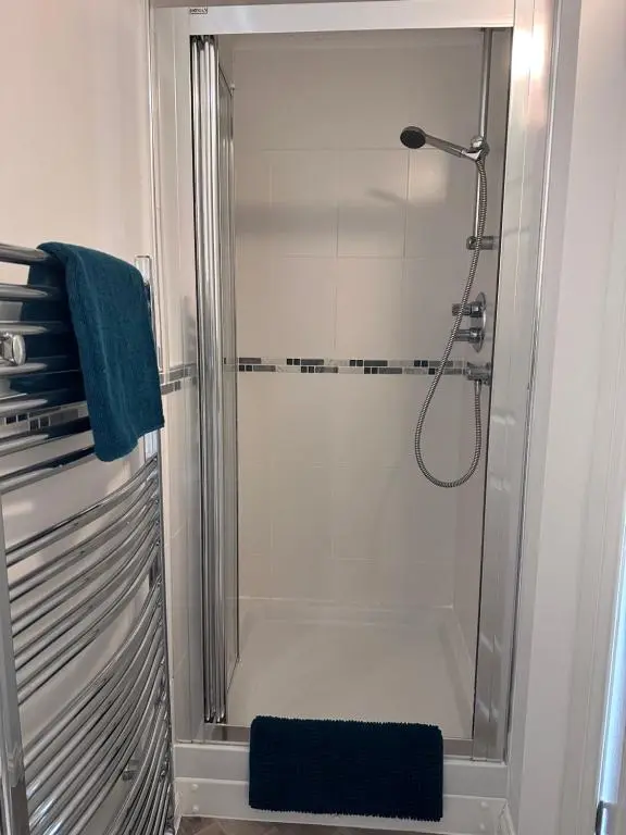 a shower with a glass door in a bathroom at The Meadow, River view apartment in South Kessock