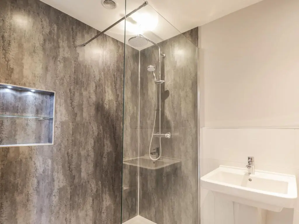a shower with a glass door next to a sink at Old Manse in Muir of Ord