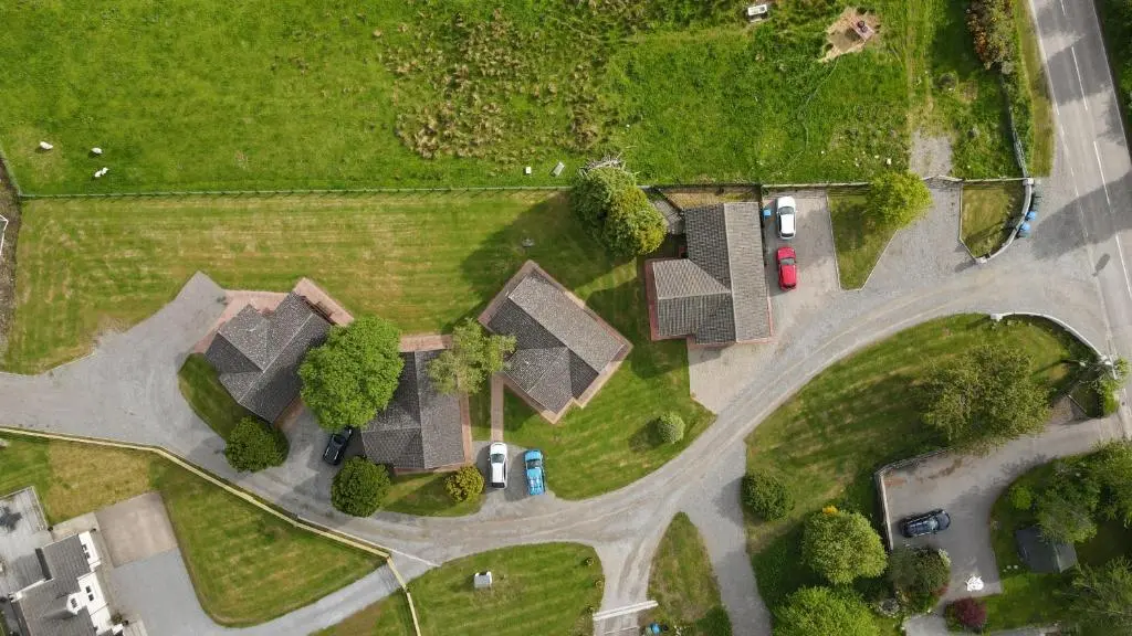 an overhead view of a house with cars on a road at Glenview Chalet Park in Inverness