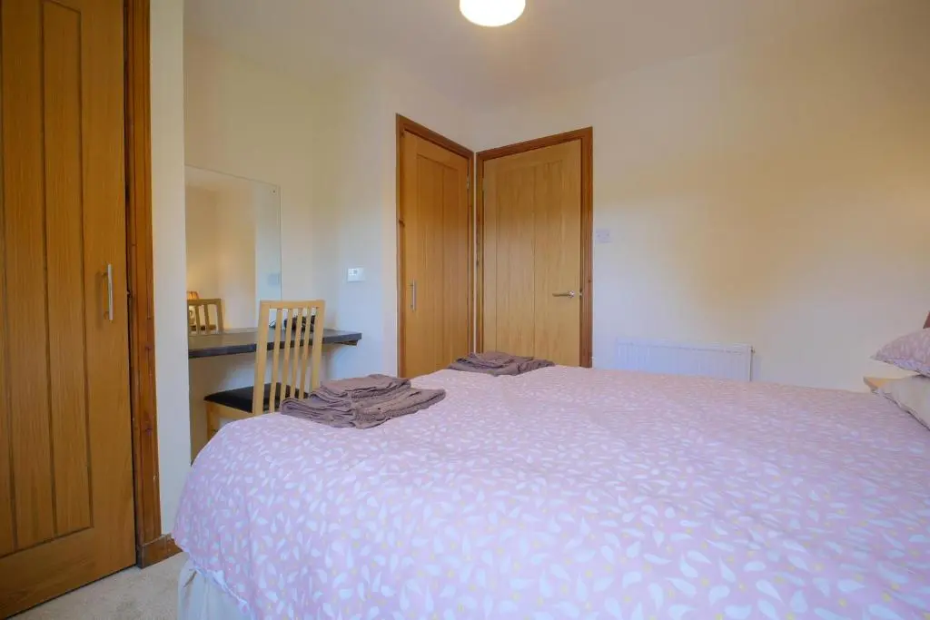 a bedroom with a large bed with a purple blanket at Glenview Chalet Park in Inverness