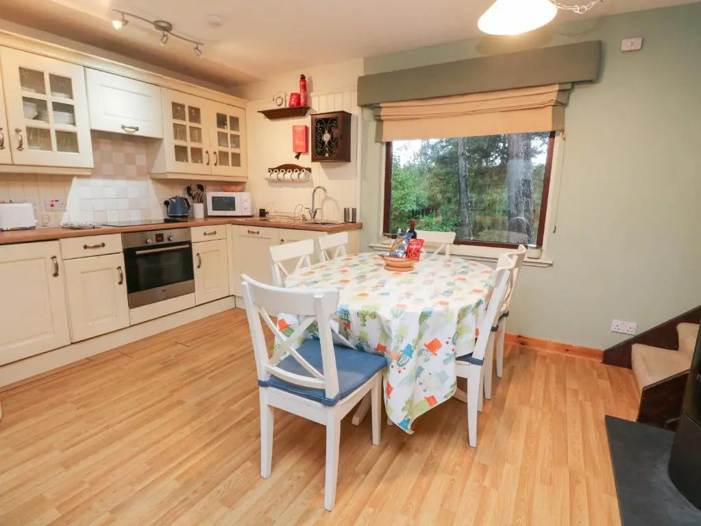 a kitchen with a table and chairs in a kitchen at The Shieling in Newtonmore