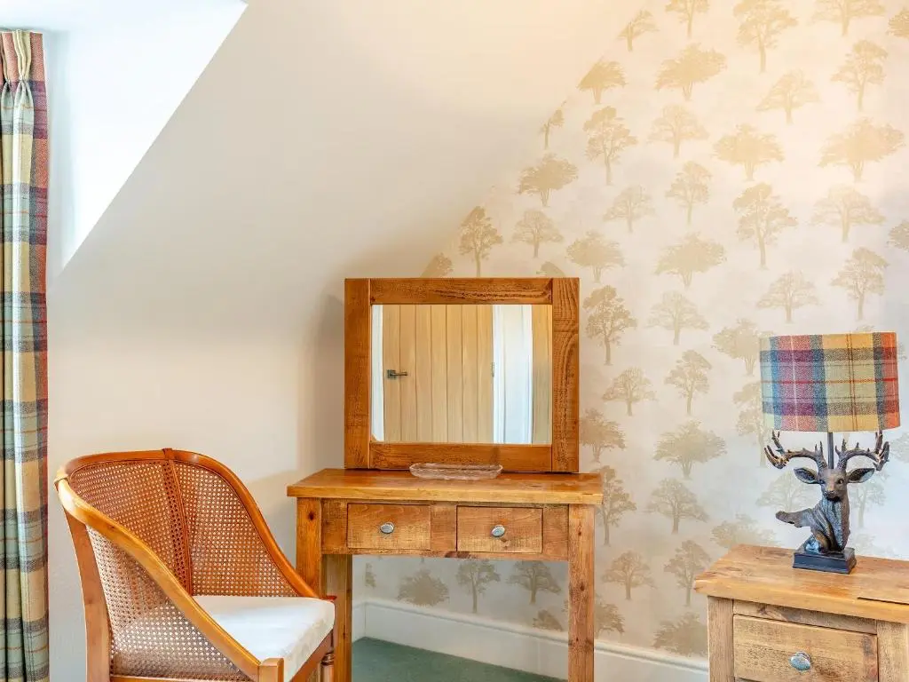 a dressing table with a mirror and a chair at Rose Cottage - Uk39245 in Inverness