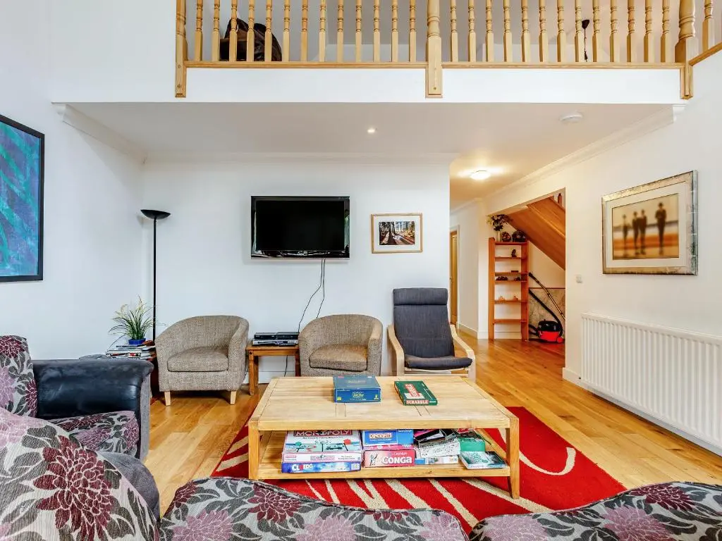 a living room with a couch and a table at Osprey Cottage- Ukc5519 in Boat of Garten