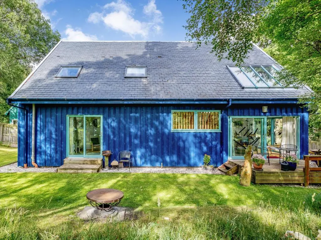 a blue house with a yard at Ptarmigan Cottage-Ukc5518 in Boat of Garten