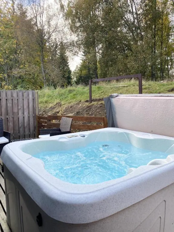 a large hot tub sitting on a deck at Kaoglen-Blossom-Hot tub-Cairngorms-Pet Friendly in Balnald