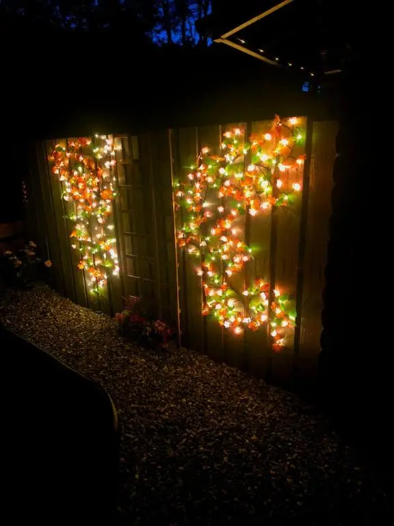 a fence with christmas lights on the side of it at Kaoglen-Blossom-Hot tub-Cairngorms-Pet Friendly in Balnald
