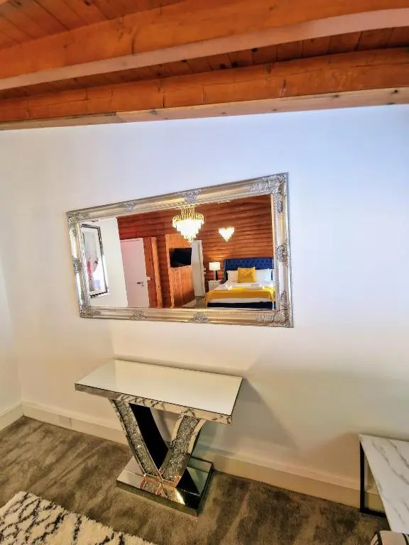 a mirror on a wall in a room with a table at Kaoglen Apollo-Hot tub-Cairngorms-Pet friendly in Balnald