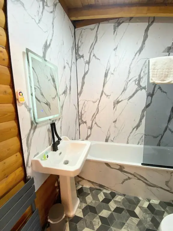 a bathroom with a sink and a mirror and a tub at Kaoglen Squirrel Drey-Hot Tub-Pet Friendly-Perth in Balnald