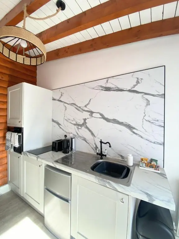 a kitchen with a sink and a marble wall at Kaoglen Zen-Feature Bath-Dunkeld-Route 500 in Balnald