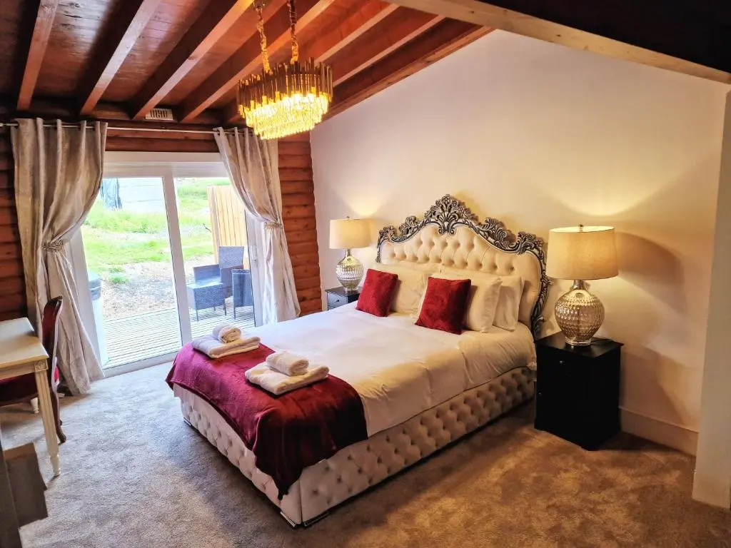 a bedroom with a large bed with a large window at Kaoglen-Spruce-Hot Tub-Forrest Setting-Pet Friendly in Balnald