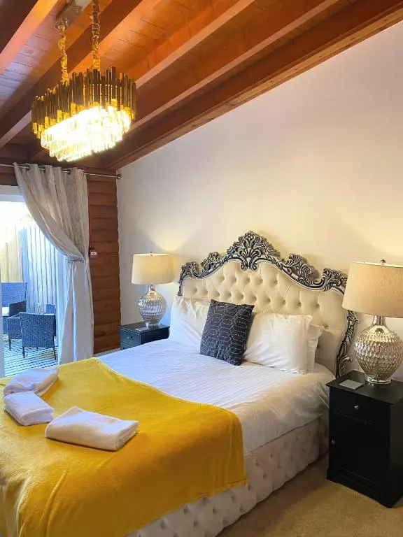 a bedroom with a large bed with a yellow blanket at Kaoglen-Spruce-Hot Tub-Forrest Setting-Pet Friendly in Balnald